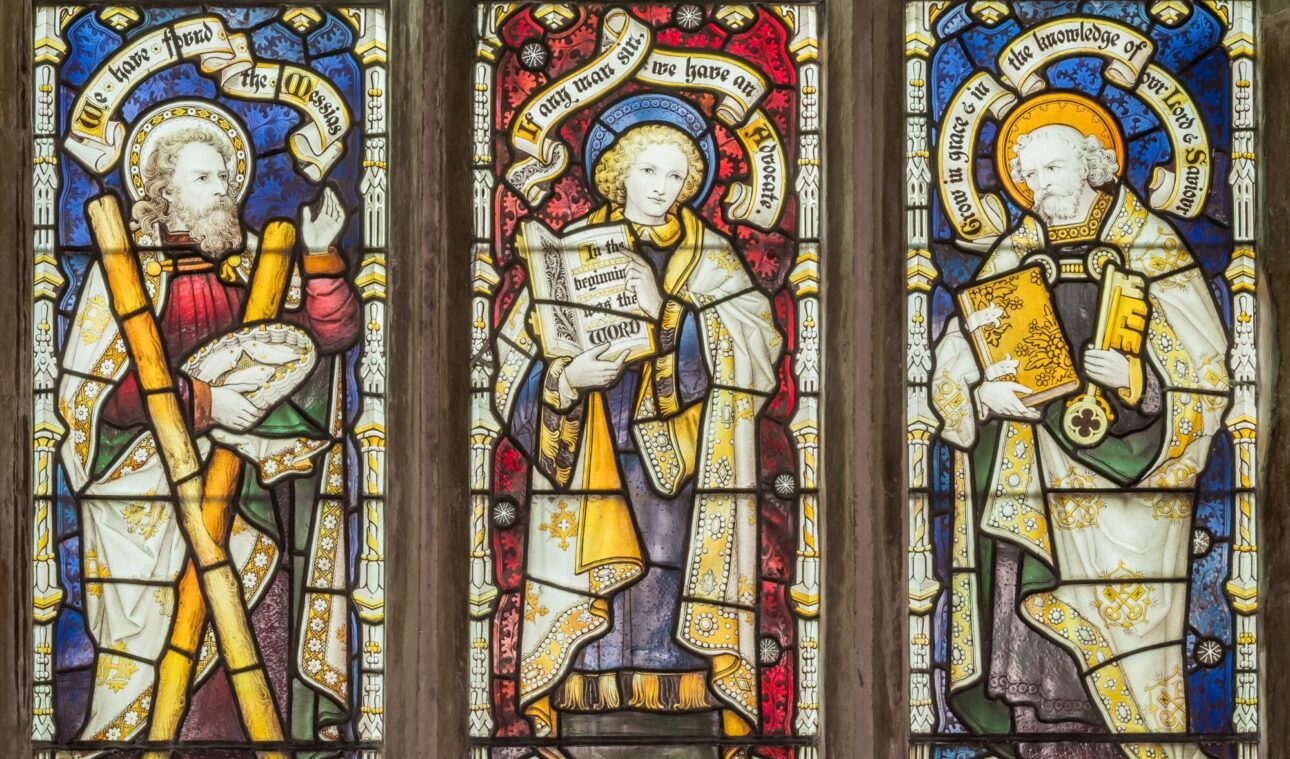 light streaming through stained glass window showing St Andrew, St John and St Peter.