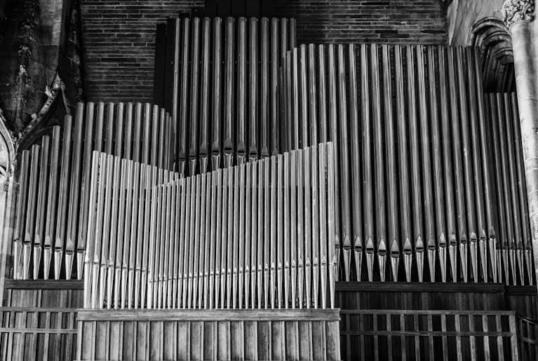 Beautiful monochrome image of a church's pipe organ showcasing intricate details and architecture.